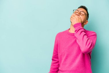 Genç İspanyol adam mavi arka planda izole edilmiş gülerek, kaygısızca, doğal duygularla.