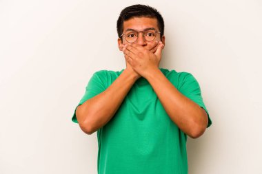 Beyaz arka planda izole edilmiş genç İspanyol adam elleriyle ağzını kapatırken şok oldu..