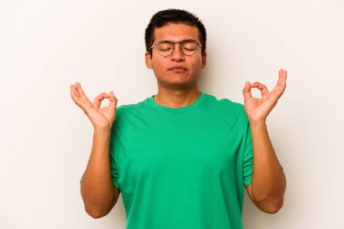 Beyaz arka planda izole olmuş genç İspanyol adam sıkı çalışma gününden sonra rahatlıyor, yoga yapıyor..