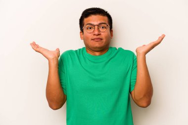 Beyaz arka planda izole edilmiş genç İspanyol bir adam. Kafası karışmış ve omuz silkiyor. Kopya alanını tutmak için..