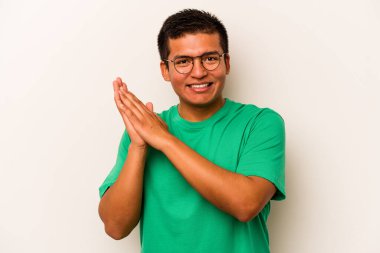 Beyaz arka planda izole edilmiş genç İspanyol adam enerjik ve rahat hissediyor, ellerini ovuşturuyor..