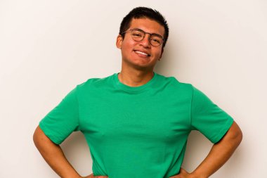 Beyaz arka planda izole edilmiş genç İspanyol bir adam. Kendine güveniyor. Kalçaları tutuyor..
