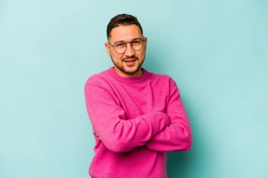 Genç İspanyol adam mavi arka planda izole edilmiş mutlu, güler yüzlü ve neşeli.