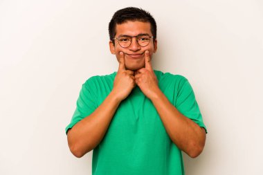 Latin kökenli genç bir adam beyaz arka planda iki seçenek arasında kuşkulanıyor..