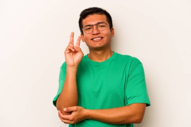 Beyaz arka planda izole edilmiş genç İspanyol adam iki numarayı parmaklarıyla gösteriyor..