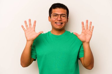 Beyaz arka planda izole edilmiş genç İspanyol adam on numarayı elleriyle gösteriyor..