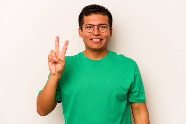 Beyaz arka planda izole edilmiş genç İspanyol adam neşeli ve kaygısız parmakları olan bir barış sembolü gösteriyor..