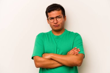 Beyaz arka planda izole edilmiş genç İspanyol adam alaycı bir ifadeyle kameraya bakıyor..