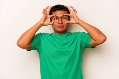 Beyaz arka planda izole edilmiş genç bir İspanyol başarılı bir fırsat yakalamak için gözlerini açık tutuyor..