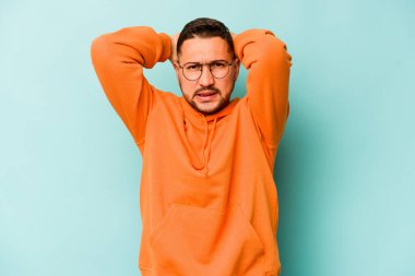 Genç İspanyol adam mavi arka planda izole edilmiş öfkeyle bağırıyor..