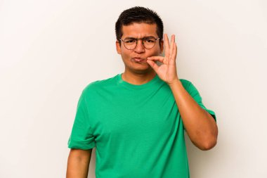 Beyaz arka planda izole edilmiş genç İspanyol adam parmakları dudaklarında bir sır saklıyor..