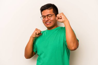 Beyaz arka planda izole edilmiş genç bir İspanyol özel bir günü kutluyor, atlıyor ve enerjiyle kollarını kaldırıyor..