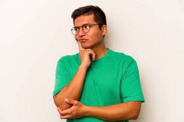 Latin kökenli genç bir adam beyaz arka planda izole edilmiş. Bir strateji planlıyor, bir iş yolu düşünüyor..