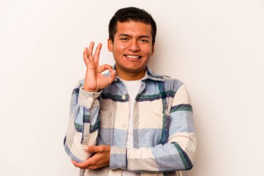 Beyaz arka planda izole edilmiş genç İspanyol bir adam bir göz kırptı ve elleriyle iyi bir jest yaptı..