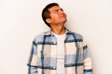 Beyaz arka planda izole edilmiş genç bir İspanyol. Rahatlamış ve mutlu bir şekilde gülüyor. Boynunda dişler var..