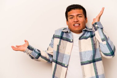 Beyaz arka planda izole edilmiş genç İspanyol bir adam avuç içinde fotokopi alanı tutuyor, el üstünde tutuyor. Şaşırmış ve mutlu..