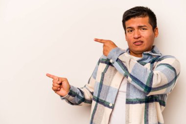 Beyaz arka planda izole edilmiş genç İspanyol adam işaret parmaklarıyla fotokopi alanını işaret ederek heyecan ve arzuyu ifade ediyor..