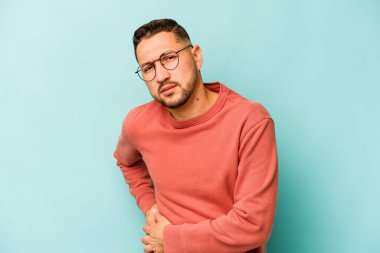 Mavi arka planda karaciğer ağrısı ve karın ağrısı çeken genç bir İspanyol..