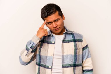 Beyaz arka planda izole edilmiş genç İspanyol bir adam şakağı parmağıyla işaret ediyor, düşünüyor ve bir göreve odaklanıyor..