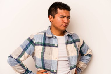 Beyaz arka planda izole edilmiş, hoşnutsuzca kaşlarını çatmış, kollarını kavuşturmuş genç bir İspanyol..