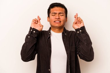 Latin kökenli genç bir adam beyaz arka planda izole edilmiş şans dilemek için şans diliyor.