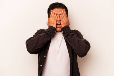 Beyaz arka planda izole edilmiş, yüzünün yarısını palmiye ile örterek eğlenen genç bir İspanyol..