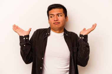 Beyaz arka planda izole edilmiş genç İspanyol bir adam. Kafası karışmış ve omuz silkiyor. Kopya alanını tutmak için..