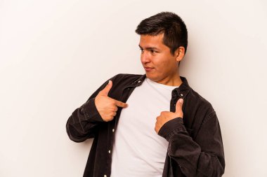 Beyaz arka planda izole edilmiş genç İspanyol adam parmağını göstererek şaşırdı, geniş bir gülümsemeyle..