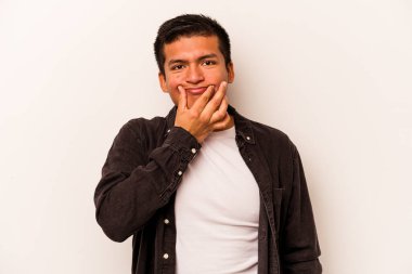 Latin kökenli genç bir adam beyaz arka planda iki seçenek arasında kuşkulanıyor..