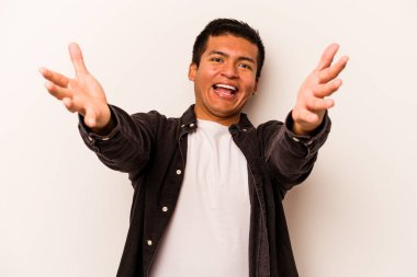 Beyaz arka planda izole edilmiş genç İspanyol adam kameraya sarıldığı için kendinden emin hissediyor..