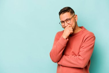 Genç İspanyol adam mavi arka planda izole edilmiş gülerek, kaygısızca, doğal duygularla.