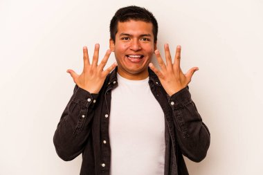 Beyaz arka planda izole edilmiş genç İspanyol adam on numarayı elleriyle gösteriyor..