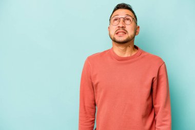 Genç İspanyol adam mavi arka planda izole edilmiş çok kızgın, öfkeli, hayal kırıklığına uğramış bağırıyor..