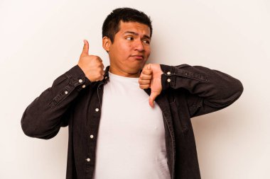 Beyaz arka planda izole edilmiş genç bir İspanyol, baş parmağını kaldırıyor, zor bir seçim.