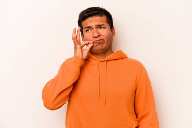 Beyaz arka planda izole edilmiş genç İspanyol adam parmakları dudaklarında bir sır saklıyor..