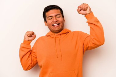 Beyaz arka planda izole edilmiş genç bir İspanyol özel bir günü kutluyor, atlıyor ve enerjiyle kollarını kaldırıyor..