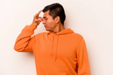 Beyaz arka planda izole edilmiş genç İspanyol bir adamın başı ağrıyor, yüzüne dokunuyor..