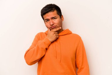 Latin kökenli genç bir adam beyaz arka planda izole edilmiş. Bir strateji planlıyor, bir iş yolu düşünüyor..