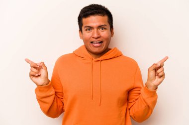 Beyaz arka planda izole edilmiş genç İspanyol adam farklı kopya alanlarını gösteriyor, birini seçiyor, parmaklarıyla gösteriyor..