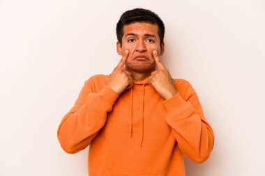 Beyaz arka planda izole edilmiş genç İspanyol bir adam ağlıyor, bir şeyden memnun değil, acı ve kafa karışıklığı konsepti..