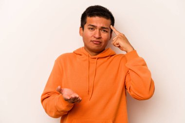 Latin kökenli genç bir adam beyaz arka planda izole edilmiş ve elinde bir ürün tutuyor..