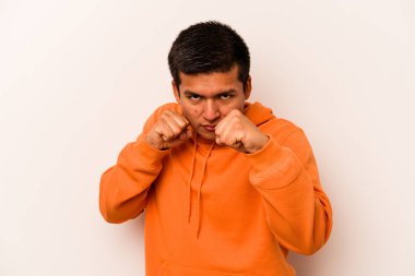 Latin kökenli genç bir adam beyaz arka planda izole edilmiş. Yumruk atıyor, sinirleniyor, kavga ediyor..