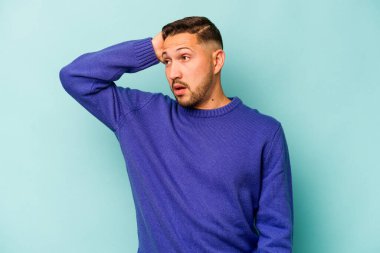 Mavi arka planda izole edilmiş genç bir İspanyol şoka uğruyor, önemli bir buluşmayı hatırlıyor..