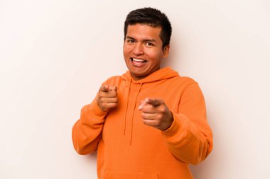 Beyaz arka planda izole edilmiş genç İspanyol adam parmaklarıyla ön tarafı işaret ediyor..