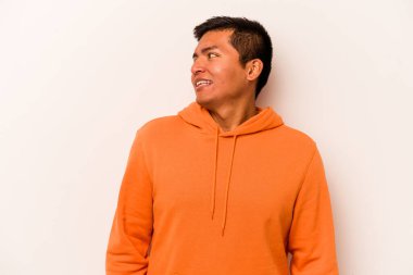 Beyaz arka planda izole edilmiş genç İspanyol adam gülüyor ve gözlerini kapıyor, rahatlamış ve mutlu hissediyor..