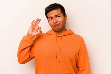 Beyaz arka planda izole edilmiş genç İspanyol bir adam bir göz kırptı ve elleriyle iyi bir jest yaptı..