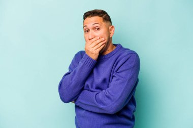Genç İspanyol adam mavi arka planda izole edilmiş korkmuş ve korkmuş..