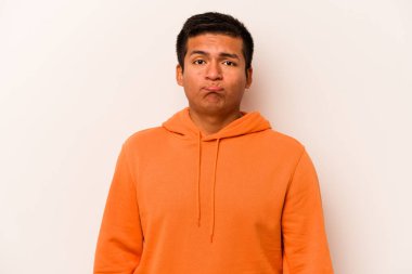 Genç İspanyol adam beyaz arka planda izole edilmiş üzgün, ciddi yüzlü, mutsuz ve hoşnutsuz..