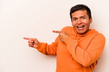 Beyaz arka planda izole edilmiş genç bir İspanyol işaret parmaklarıyla işaret ederek heyecanlanıyor..