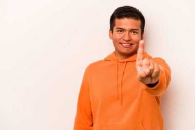 Beyaz arka planda izole edilmiş genç İspanyol bir numara parmağıyla görünüyor..